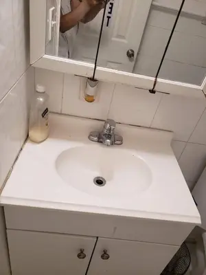 a white sink in a bathroom with a person in a mirror at Miami Cheapest Place in Miami