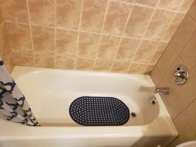 a bath tub with a black grate in a bathroom at Miami Cheapest Place in Miami