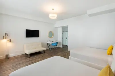 a white room with a bed and a chair at President Hotel in Miami Beach