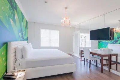 a bedroom with a white bed and a dining table at President Hotel in Miami Beach