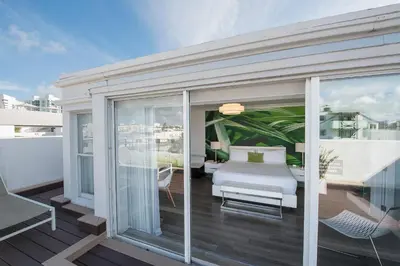 a balcony with a bed and a table and chairs at President Hotel in Miami Beach