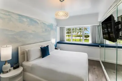 a bedroom with a white bed and a window at Penguin Hotel in Miami Beach