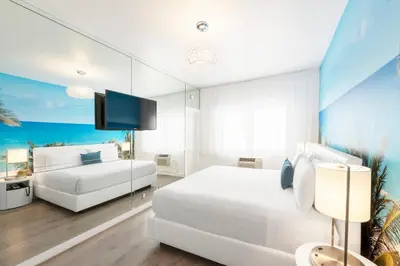 a bedroom with two beds and a flat screen tv at Penguin Hotel in Miami Beach