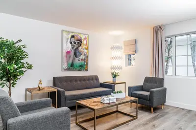 a living room with two couches and a table at Essex House Hotel in Miami Beach
