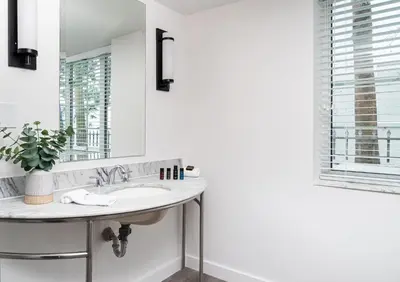 a bathroom with a sink and a mirror at Essex House Hotel in Miami Beach