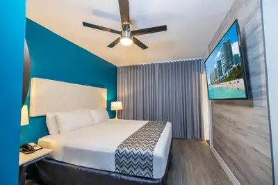 a bedroom with a bed and a ceiling fan at Colony Hotel in Miami Beach