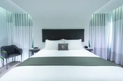 a bedroom with a large white bed and a chair at Kent Hotel in Miami Beach