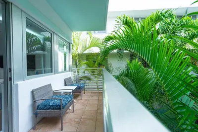 a balcony with chairs and tables and palm trees at Kent Hotel in Miami Beach