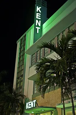 a hotel with a green sign on the side of it at Kent Hotel in Miami Beach