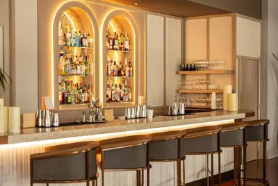 a bar in a restaurant with a counter with stools at Balfour Miami Beach, a Registry Collection Hotel in Miami Beach