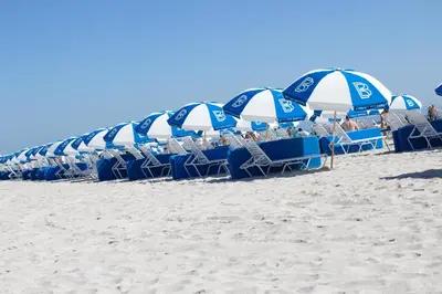 a line of chairs and umbrellas on a beach at Aqua Hotel & Suites in Miami Beach