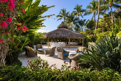 a patio with a table and chairs and palm trees at The Palms Hotel & Spa in Miami Beach