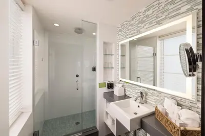 a bathroom with a sink and a shower and a mirror at The Palms Hotel & Spa in Miami Beach