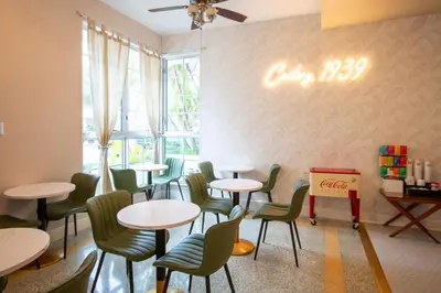 a restaurant with tables and chairs and a window at Century Hotel in Miami Beach
