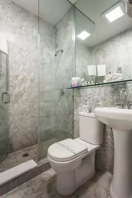 a bathroom with a toilet and a sink and a shower at Century Hotel in Miami Beach