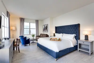 a hotel room with a large bed and a living room at Clinton Hotel South Beach in Miami Beach