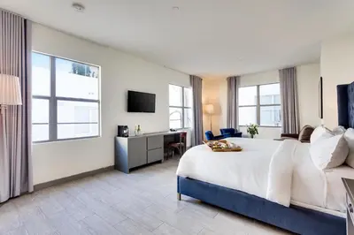 a hotel room with a large bed and a desk at Clinton Hotel South Beach in Miami Beach