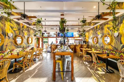 a restaurant with wooden tables and chairs and colorful walls at Clinton Hotel South Beach in Miami Beach