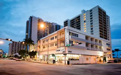 a building on the corner of a street with two tall buildings at Lorraine Hotel in Miami Beach