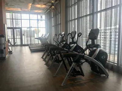 a gym with rows of cardio equipment in a room with windows at Hide House in Hollywood