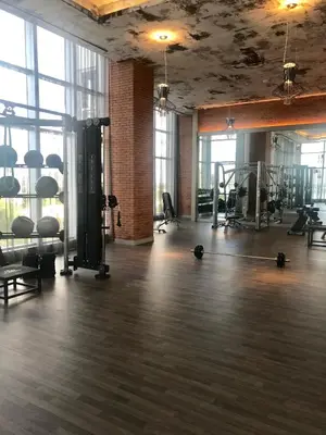 a gym with treadmills and equipment in a room with windows at Hide House in Hollywood