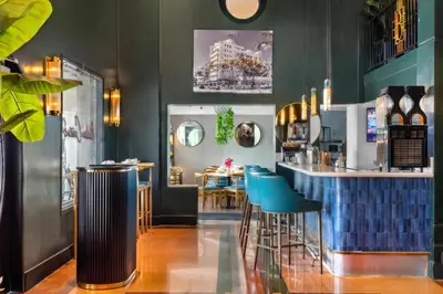 a restaurant with a bar with blue stools at Beacon South Beach Hotel in Miami Beach