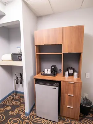 a kitchen with a desk and a refrigerator in a room at Regency Miami Airport by Sonesta in Miami