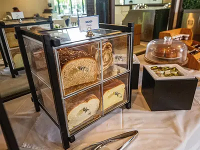 a display case filled with different types of bread at Regency Miami Airport by Sonesta in Miami