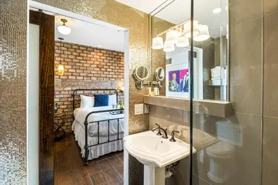 a bathroom with a sink and a mirror and a bed at Cavalier South Beach Hotel in Miami Beach