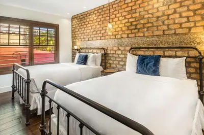 two beds in a room with a brick wall at Cavalier South Beach Hotel in Miami Beach