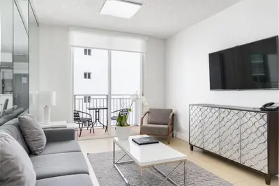 a living room with a couch and a tv at Fortune House Hotel Suites in Miami