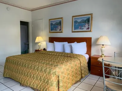 a hotel room with a bed and a table at International Inn on the Bay in Miami Beach