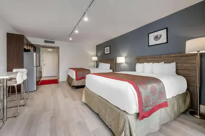 a hotel room with two beds and a table at Ramada Plaza by Wyndham Marco Polo Beach Resort in Miami Beach