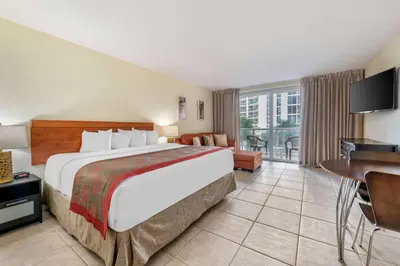 a hotel room with a large bed and a desk at Ramada Plaza by Wyndham Marco Polo Beach Resort in Miami Beach