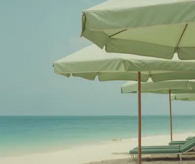 two beach chairs and umbrellas on the beach at The Shelborne by Proper, a Member of Design Hotels in Miami Beach