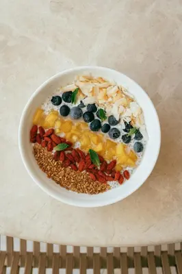 a bowl of food with fruit and nuts on a table at The Shelborne by Proper, a Member of Design Hotels in Miami Beach