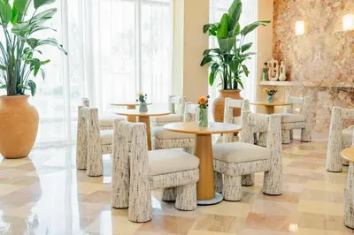 a restaurant with tables and chairs and plants at The Shelborne by Proper, a Member of Design Hotels in Miami Beach