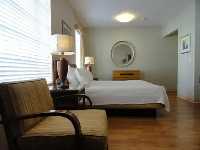 a bedroom with a bed and a chair and a mirror at Viscay Hotel in Miami Beach
