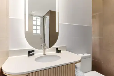 a bathroom with a sink and a mirror at Waldorf Towers South Beach in Miami Beach