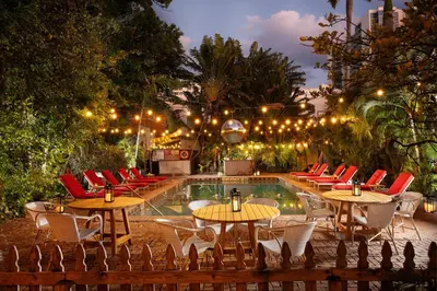 a pool with tables and chairs next to a resort at Freehand Miami in Miami Beach
