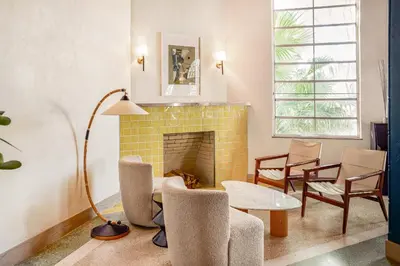 a living room with a fireplace and a table and chairs at Freehand Miami in Miami Beach