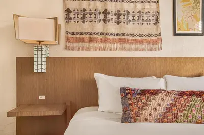 a hotel room with a bed with a lamp and a curtain at Freehand Miami in Miami Beach