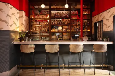a bar with four stools in a room at Freehand Miami in Miami Beach