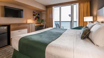 a hotel room with a bed with a view of the ocean at Best Western Plus Atlantic Beach Resort in Miami Beach