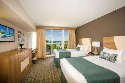 a hotel room with two beds and a window at Best Western Plus Atlantic Beach Resort in Miami Beach