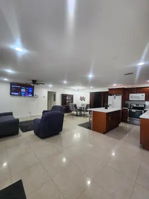 a large living room with couches and a kitchen at The Jazzy Escape in Miami