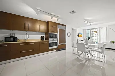 a kitchen with wooden cabinets and a table and chairs at Luxury 1 BR Condo W Icon Brickell-Waterviews in Miami