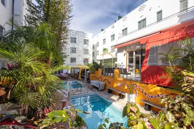 a hotel with a swimming pool next to a building at Viajero Miami in Miami Beach