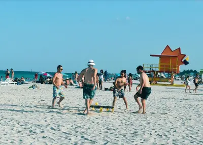 a group of men walking on a beach at Viajero Miami in Miami Beach