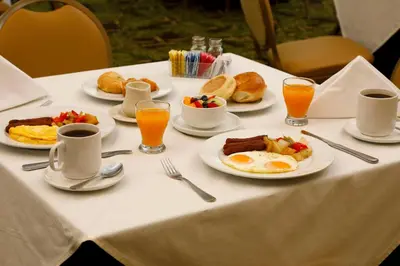 a table topped with plates of breakfast food and orange juice at Sea View Hotel in Miami Beach
